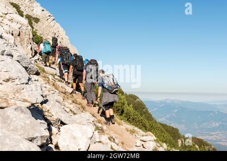 Mountain hiking, hikers on steep slope ascending Sinanitsa Peak in Pirin National Park and Reserve, Pirin Mountain, Bulgaria, Balkans, Europe Stock Photo