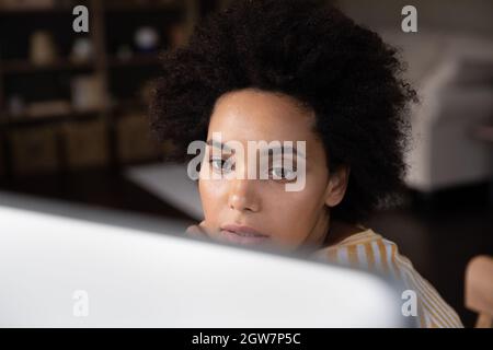 Close up concentrated african american woman working on computer. Stock Photo