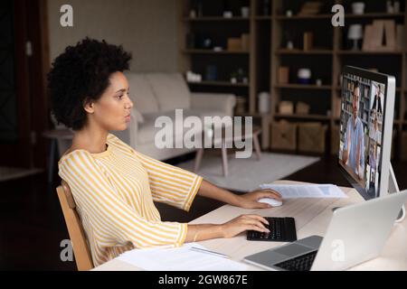 Focused millennial african american woman holding distant negotiations meeting. Stock Photo