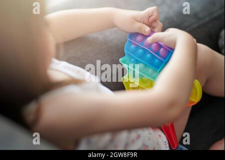 Fun trend popit toy in kid hands macro close up view Stock Photo