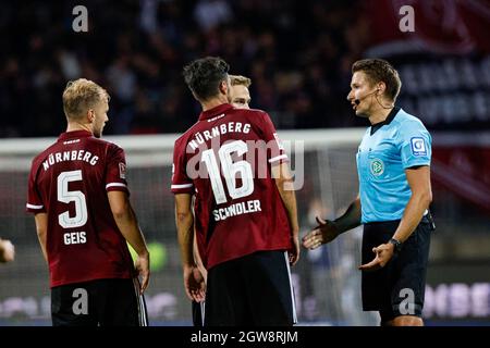 Nuremberg, Germany. 02nd Oct, 2021. Soccer: 2. Bundesliga, 1. FC Nürnberg - Hannover 96, Matchday 9, Max-Morlock-Stadion Referee Tobias Reichel (right) discusses with Nürnberg players after the end of the game. Credit: Löb Daniel/dpa - IMPORTANT NOTE: In accordance with the regulations of the DFL Deutsche Fußball Liga and/or the DFB Deutscher Fußball-Bund, it is prohibited to use or have used photographs taken in the stadium and/or of the match in the form of sequence pictures and/or video-like photo series./dpa/Alamy Live News Stock Photo