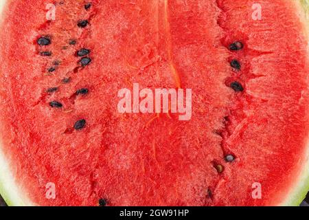 Ripe juicy watermelon with dark seeds macro texture. Freshly cut red sweet watermelon close-up. Half of delicious organic water melon pulp. Macro. Stock Photo
