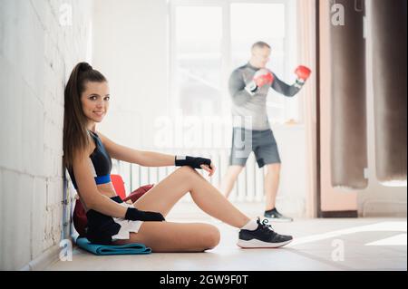 Girl boxer prepares for a fight by rolling bandages on her fists. Women's boxing Stock Photo