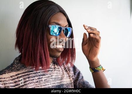 Funny black boy with long hair and sunglasses laughing Stock Photo