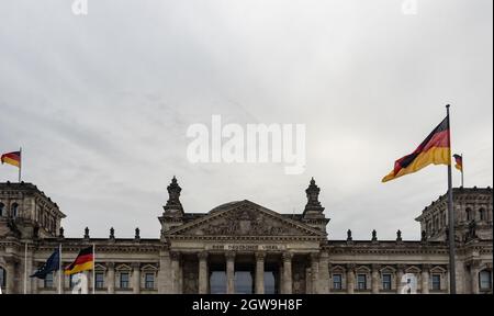 Berlin, Germany. 03rd Oct, 2021. Germany flags are seen at the Reichstag on German Unity Day. The German Unity Day Act came into force on 4 August 1953. In future, 17 June was to serve as a statutory national memorial day to commemorate the 1953 uprising in the GDR. Since German reunification in 1990, the 'Day of German Unity' has been celebrated on 3 October. Credit: Paul Zinken/dpa/Alamy Live News Stock Photo