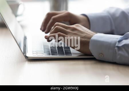 Close up male hands typing on modern laptop keyboard Stock Photo