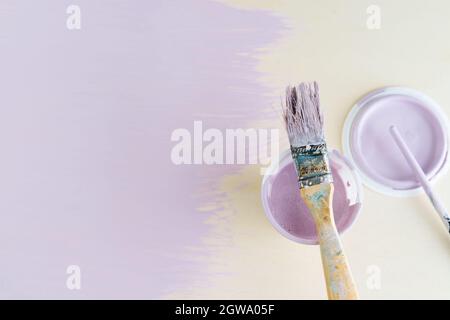 Mauve paint pot and brush on yellow background. Copy space. Stock Photo