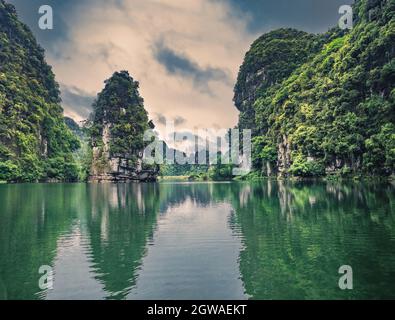 Spectacular landscape in Ninh Binh with mountains, caves and boat tour on river. Exotic tropical landscape with hills and river. Stock Photo