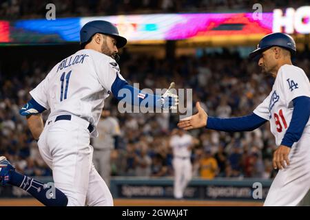 Los Angeles Dodgers' AJ Pollock, right, reacts with third base coach Dino  Ebel after hitting a …