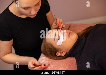 Woman With Cotton Pads Lying During Eyelash Extension Procedure Stock Photo