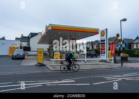 WIMBLEDON LONDON, UK. 3 Oct, 2021. A cyclist rides past  a Shell petrol filling station in Wimbledon, South West London which has closed due to the the fuel supply crisis. The government has announced the military drivers will be deployed from Monday 4th October to deliver fuel to forecourts and ease the shortage to avoid a tough winter ahead. Credit: amer ghazzal/Alamy Live News Stock Photo