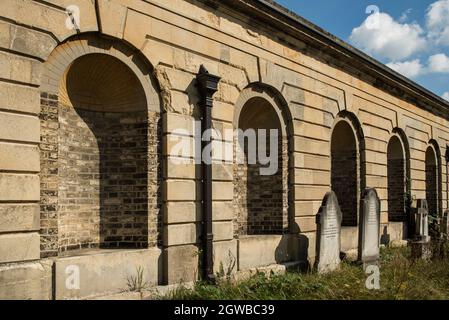 Gravestones behind the colonnades at a Victorian cemetery, one of the magnificent seven Victorian cemeteries in London, UK. Stock Photo