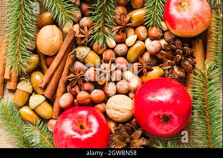 New Year and Christmas background of organic natural ingredients - nuts apples, anise, cinnamon sticks. the concept of New Year holidays. Stock Photo
