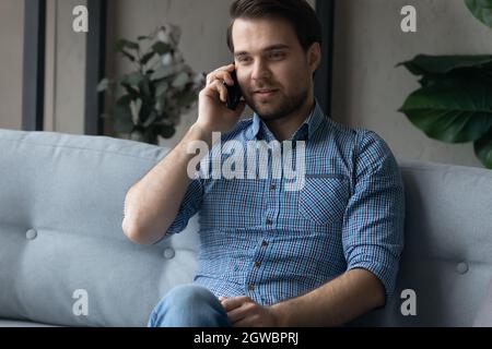 Smiling man talking on phone, enjoying pleasant conversation Stock Photo