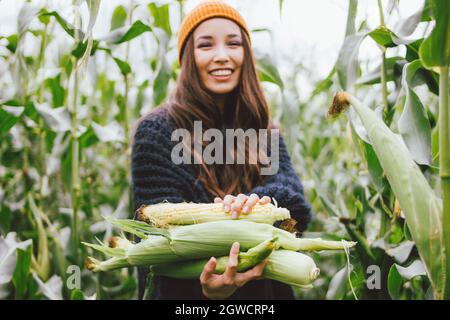 Beautiful Carefree Long Hair Asian Girl In Yellow Hat And Knitted Sweater In Autumn Corn Field