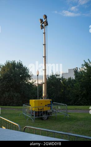 Moble fuel consumption light tower over grass during daylight performance. Sunset blue sky background Stock Photo