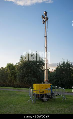 Moble fuel consumption light tower over grass during daylight performance. Sunset blue sky background Stock Photo