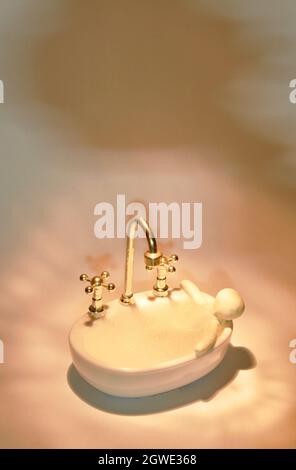clay man bath in toy bathtub and water tap for used in bathroom full with soap bubble on white background Stock Photo