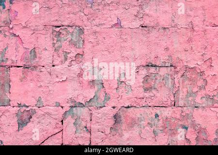 peeled off old pink paint on flat rough brick wall surface - full frame background and texture Stock Photo