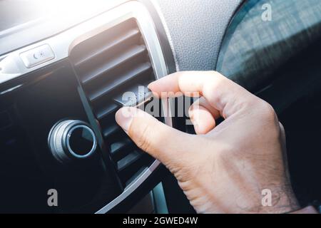 Driver hand adjusting wind direction of air vent on console in the car, Automotive parts concept. Stock Photo