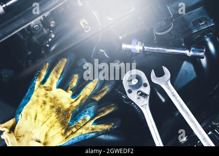 Mechanic tools place on the engine car such as gloves,socket spanner,combination wrench, Car maintenance service concept. Stock Photo