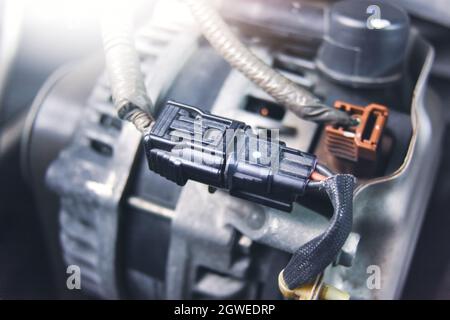 Connector socket and wire of the car alternator or generator in engine compartment. Autmotive parts concept. Stock Photo