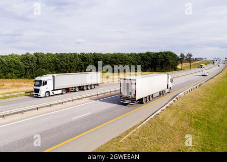 Trucks with white trailers on the highway.  Stock Photo