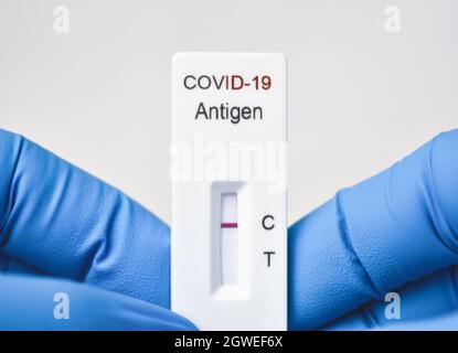 Medical personnel showing Covid-19 negative test result of the antigen rapid test kit on white background,Coronavirus infectious protect concept Stock Photo