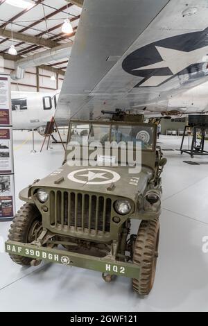 A WW II Jeep under the wing of a Boeing B-17G Flying Fortress bomber in the Pima Air & Space Museum, Tucson, Arizona. Stock Photo
