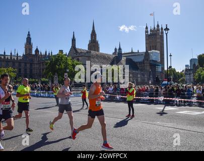 London, United Kingdom. 3rd October 2021. Runners pass through Parliament Square during the 2021 London Marathon. Credit: Vuk Valcic / Alamy Live News
