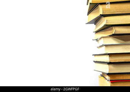 Stack of books on a white background. The books are on top of each other close-up. Side view. Stock Photo