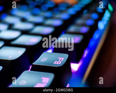 Gamer keyboard with neon backlight macro defocused close up. Online games and virtual reality concept background. Stock Photo