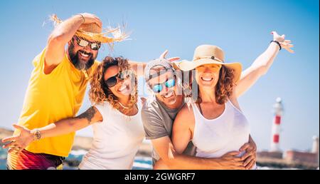 Group of happy people and cheerful adults friends having fun together during summer vacation. Portrait of two caucasian couples posing on holiday tour Stock Photo