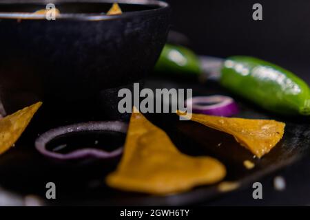 Bowl of guacamole on Mexican comal decorated with tortilla chips