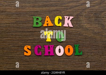 Inscription of the words of the slogan Back to school in multi-colored letters on a beautiful background. Colorful letters of the English alphabet Stock Photo
