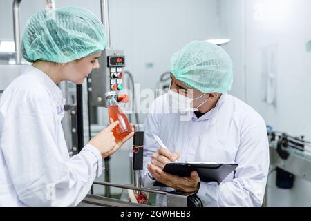 Quality control and food safety team inspection the product standard in the food and drink factory production line. Stock Photo