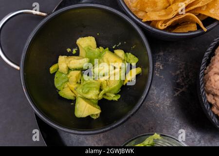 Bowl of guacamole on Mexican comal decorated with tortilla chips