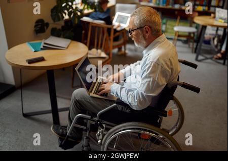 Adult disabled man using laptop, top view Stock Photo