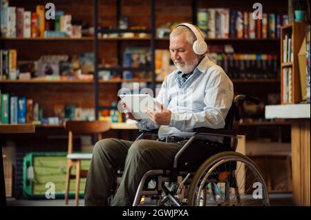 Adult disabled man in wheelchair listen to music Stock Photo