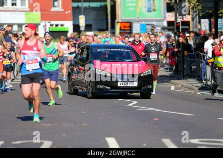 London, UK. 3rd October 2021; London, England: The Virgin Money 2021 London Marathon: Sponsor car driving through runners on Butcher Row, Limehouse between mile 21 and 22. Credit: Action Plus Sports Images/Alamy Live News