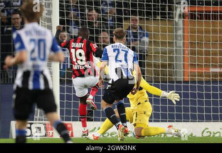 03 October 2021, North Rhine-Westphalia, Bielefeld: Football: Bundesliga, Arminia Bielefeld - Bayer Leverkusen, Matchday 7 at the SchücoArena. Bielefeld's Cedric Brunner (2nd from right) and goalkeeper Stefan Ortega (right) cannot prevent Leverkusen's goal scorer Moussa Diaby (3rd from right) from scoring 0:1. Photo: Friso Gentsch/dpa - IMPORTANT NOTE: In accordance with the regulations of the DFL Deutsche Fußball Liga and/or the DFB Deutscher Fußball-Bund, it is prohibited to use or have used photographs taken in the stadium and/or of the match in the form of sequence pictures and/or video-li Stock Photo