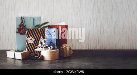 Christmas sale, Xmas shopping, Winter holiday sales, Black Friday. Many paper shopping bags and gift boxes with Christmas decorations on table. Stock Photo