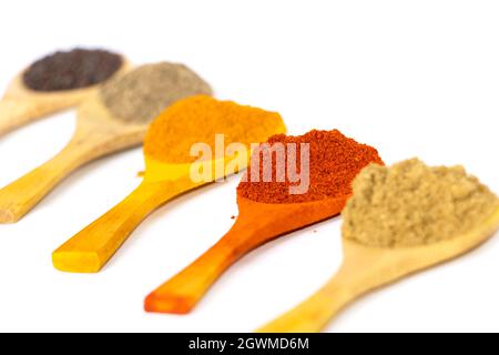 Closeup Image Of Indian Curry Powders In Wooden Spoon. White Background. Selective Focus Stock Photo