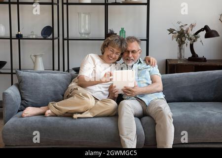 Happy bonding mature couple using digital tablet. Stock Photo