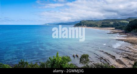 panoramic view of the Asturian coast viewed from Lastres, with white sandy beaches mixed with green mountains and a blue sky with clouds Stock Photo