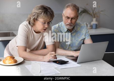 Happy middle aged family managing household expenditures. Stock Photo