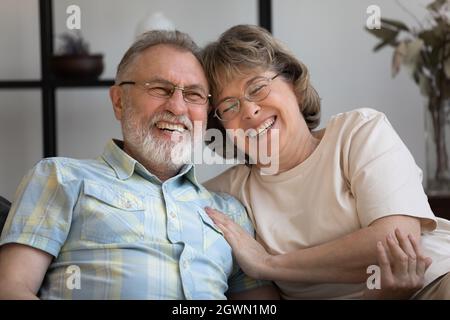 Happy old mature bonding married couple laughing at funny joke. Stock Photo