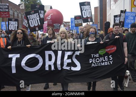 Manchester, UK, 3rd October, 2021. People with a banner at the front of a national demonstration, organised by the People's Assembly, entitled: Protest The Tory Party Conference in Manchester. The Conservative Party Conference is taking place 3rd October to 6th October, 2021, at the Manchester Central Convention Complex. Demonstrators marched from Whitworth Park, on Oxford Road, to the convention centre. Credit: Terry Waller/Alamy Live News
