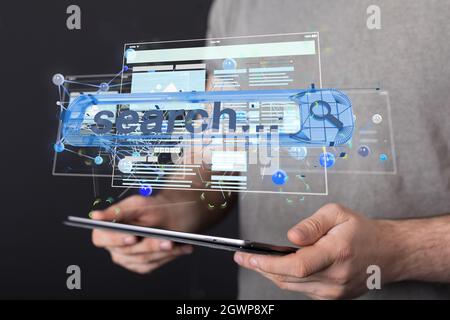 A hologram of the interface of a web application projected from a tablet on a businessman's hands Stock Photo