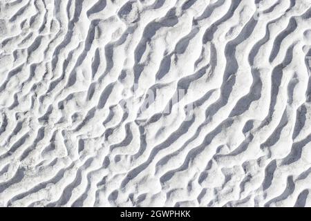Gray texture background of Pamukkale calcium travertine in Turkey, pattern of diagonal waves, close-up. Stock Photo